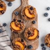 almond butter peach blueberry baked oatmeal cups on a wooden board