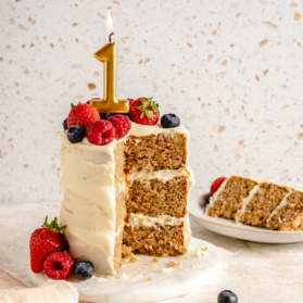 smash cake topped with a candle on a cake stand