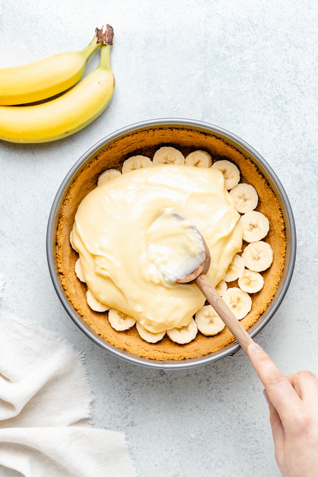 spreading banana cream pie filling into a pie crust