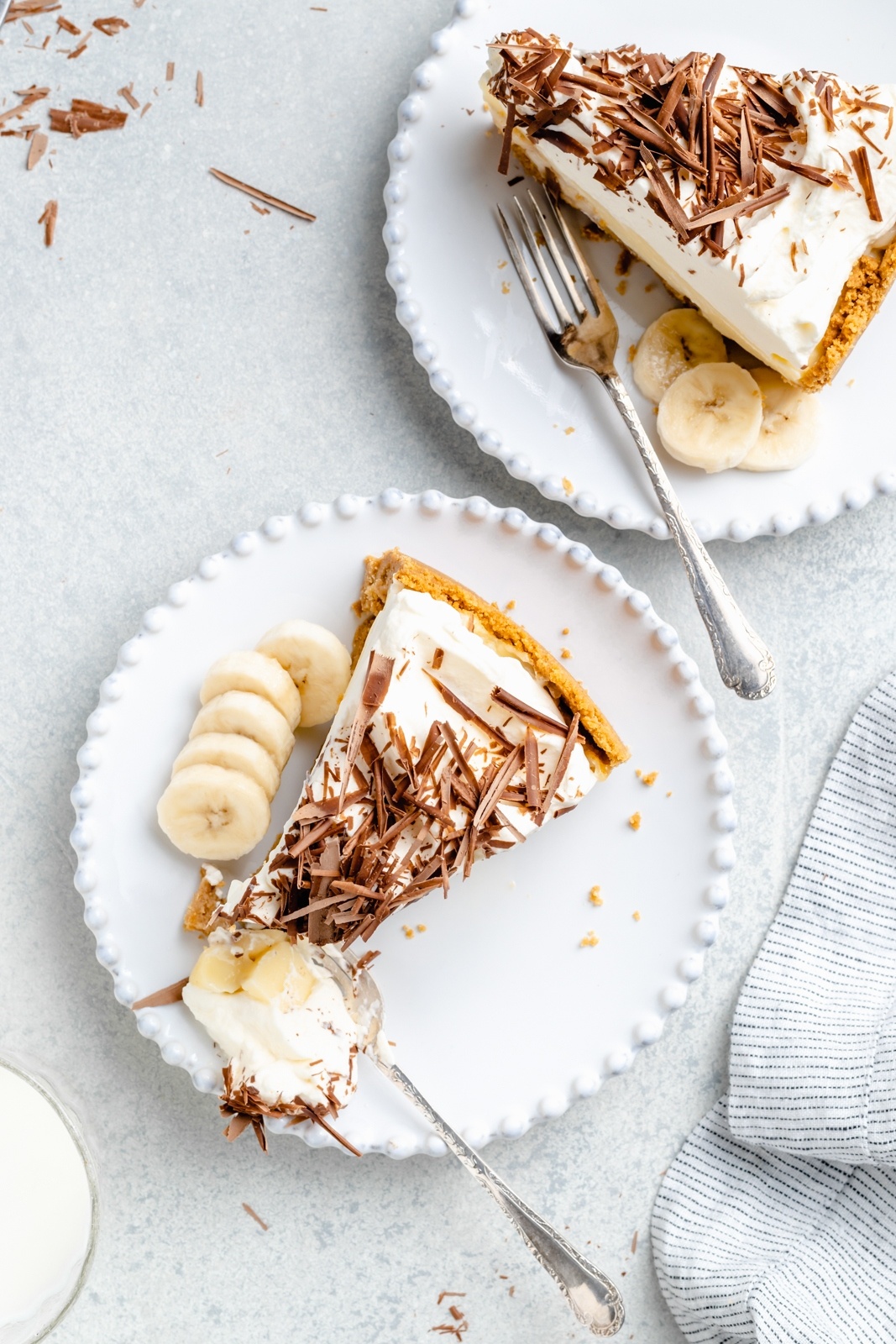 two slices of banana cream pie on plates