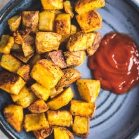 crispy breakfast potatoes on a plate with ketchup