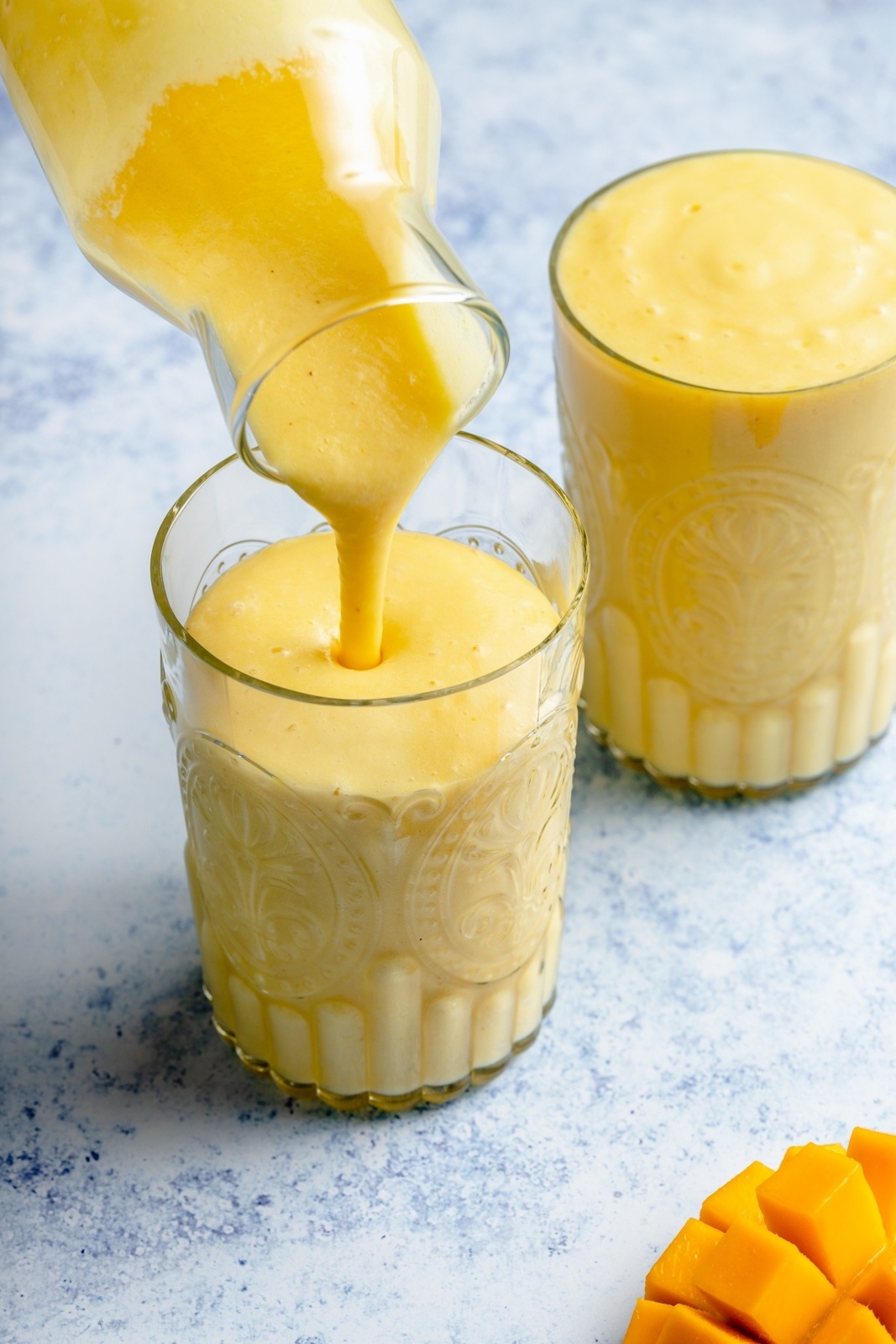 pouring a turmeric smoothie into a glass