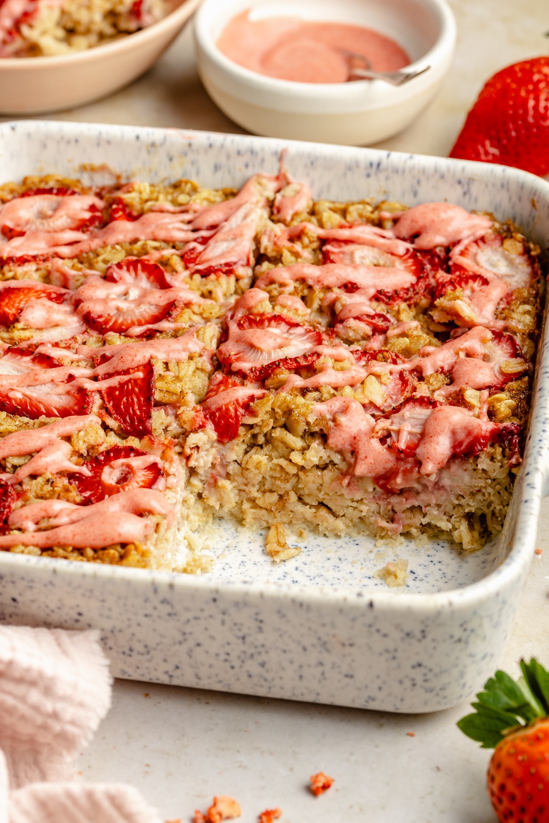 healthy strawberry baked oatmeal in a pan with a slice cut out