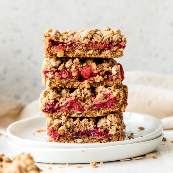 four tart cherry pie bars in a stack on a plate