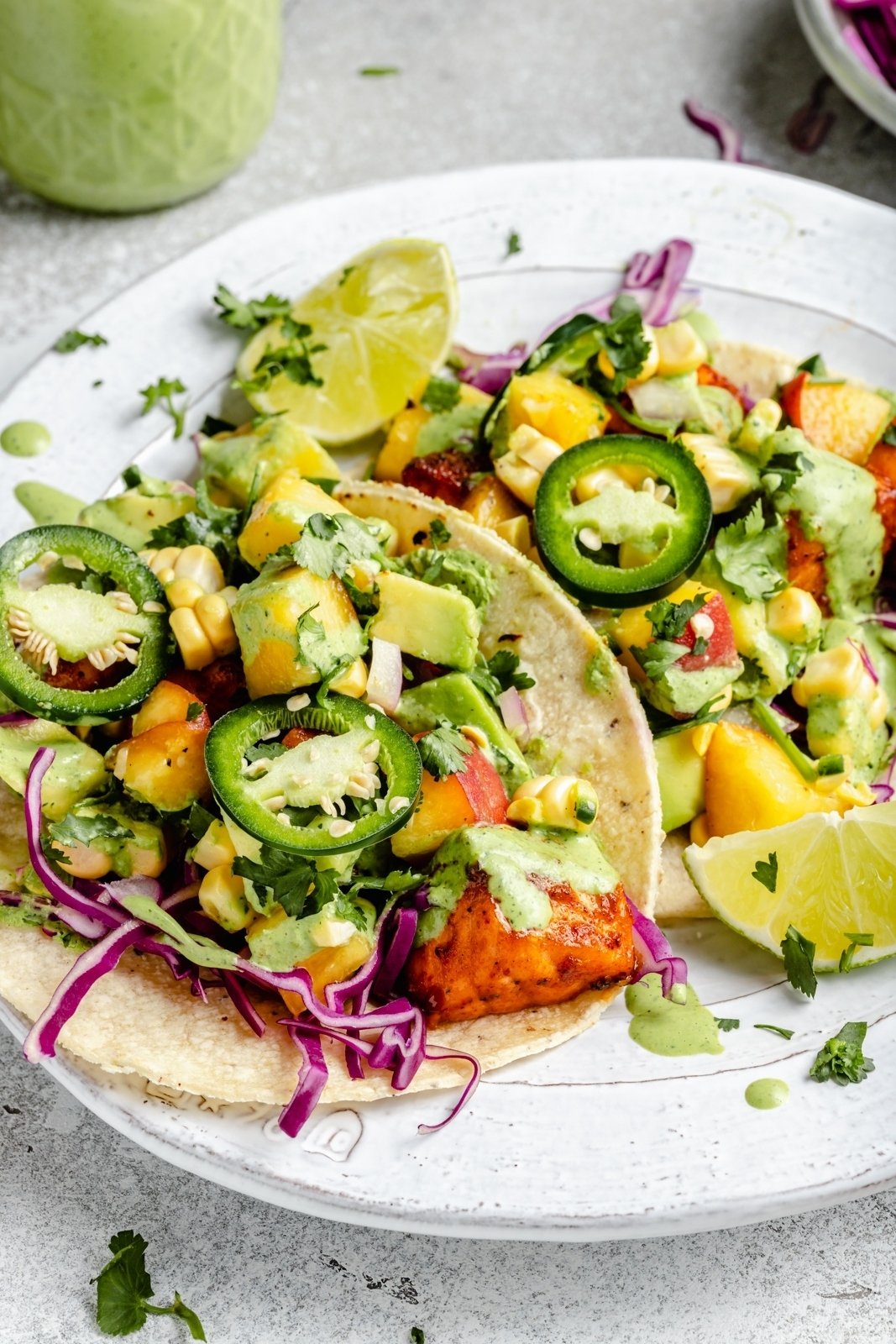 two chipotle salmon tacos with peach salsa on a plate