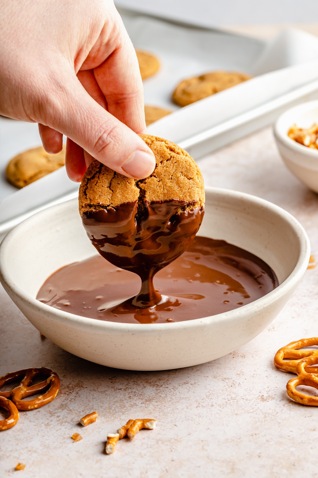 dipping a peanut butter cookie in melted chocolate