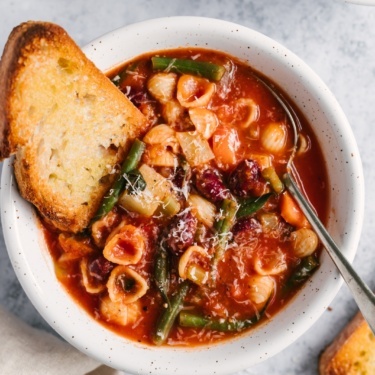 classic minestrone soup in a bowl with garlic bread