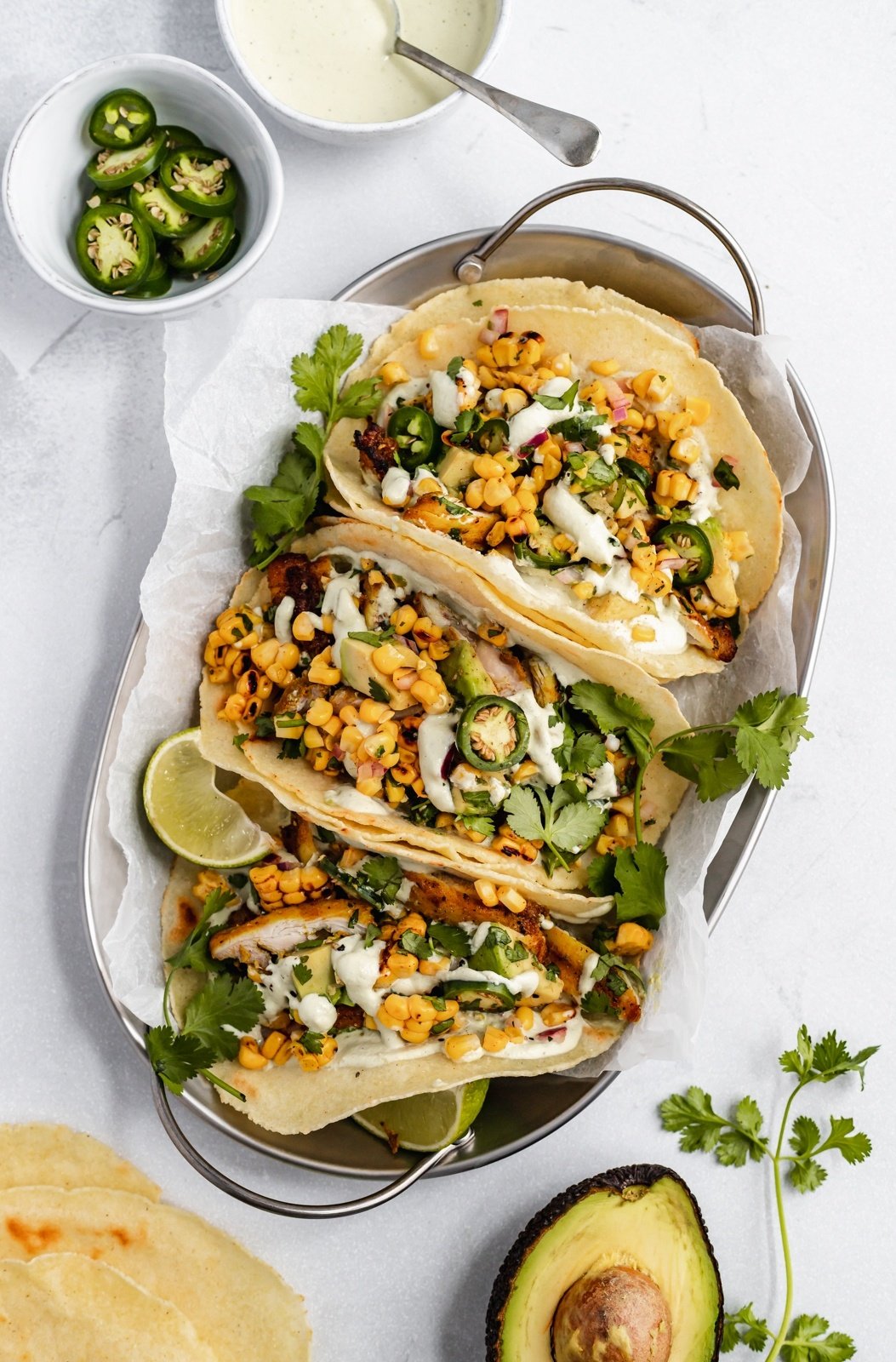 three healthy street corn chicken tacos in a basket