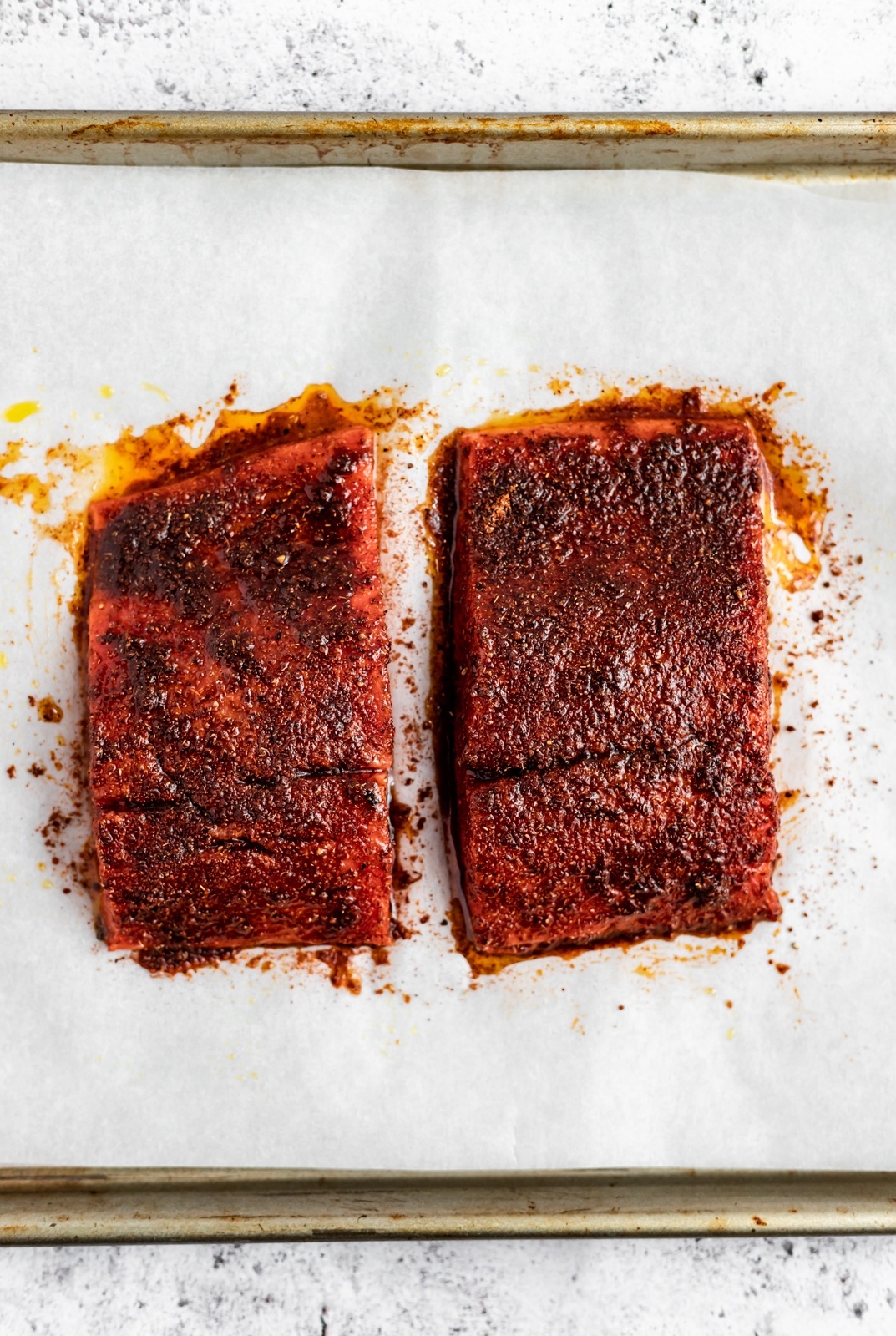 two pieces of salmon on a baking sheet to make salmon taco bowls