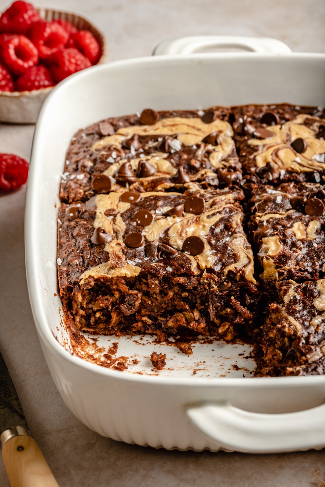 chocolate peanut butter baked oatmeal in a baking dish with a slice cut out