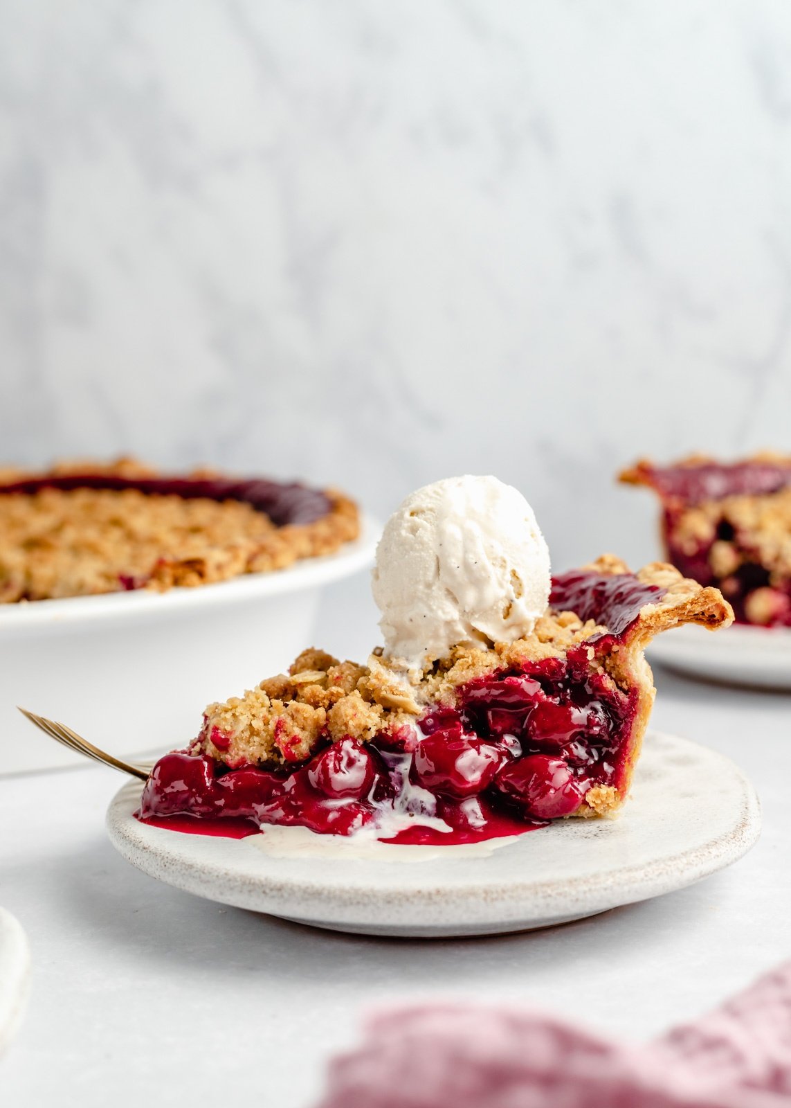 slice of tart cherry pie topped with ice cream