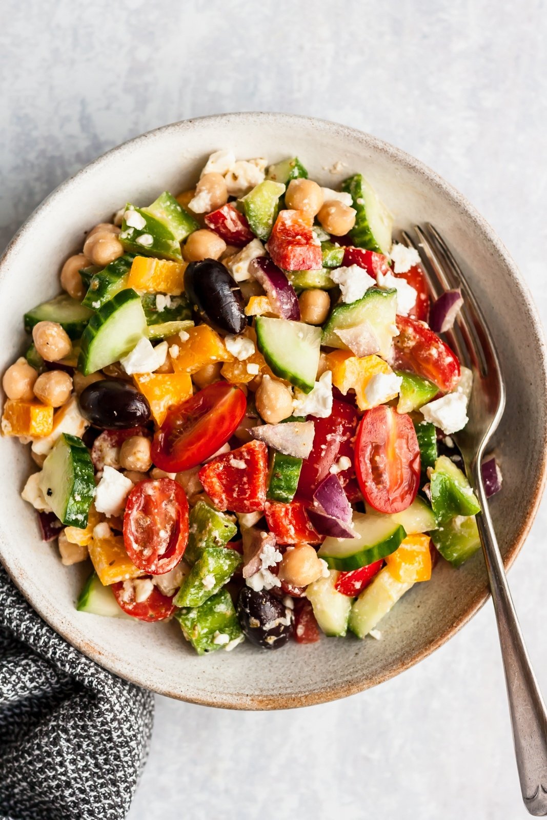 greek chickpea salad in a bowl with a fork