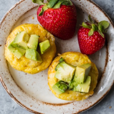 sausage egg and cheese muffins on a plate with strawberries