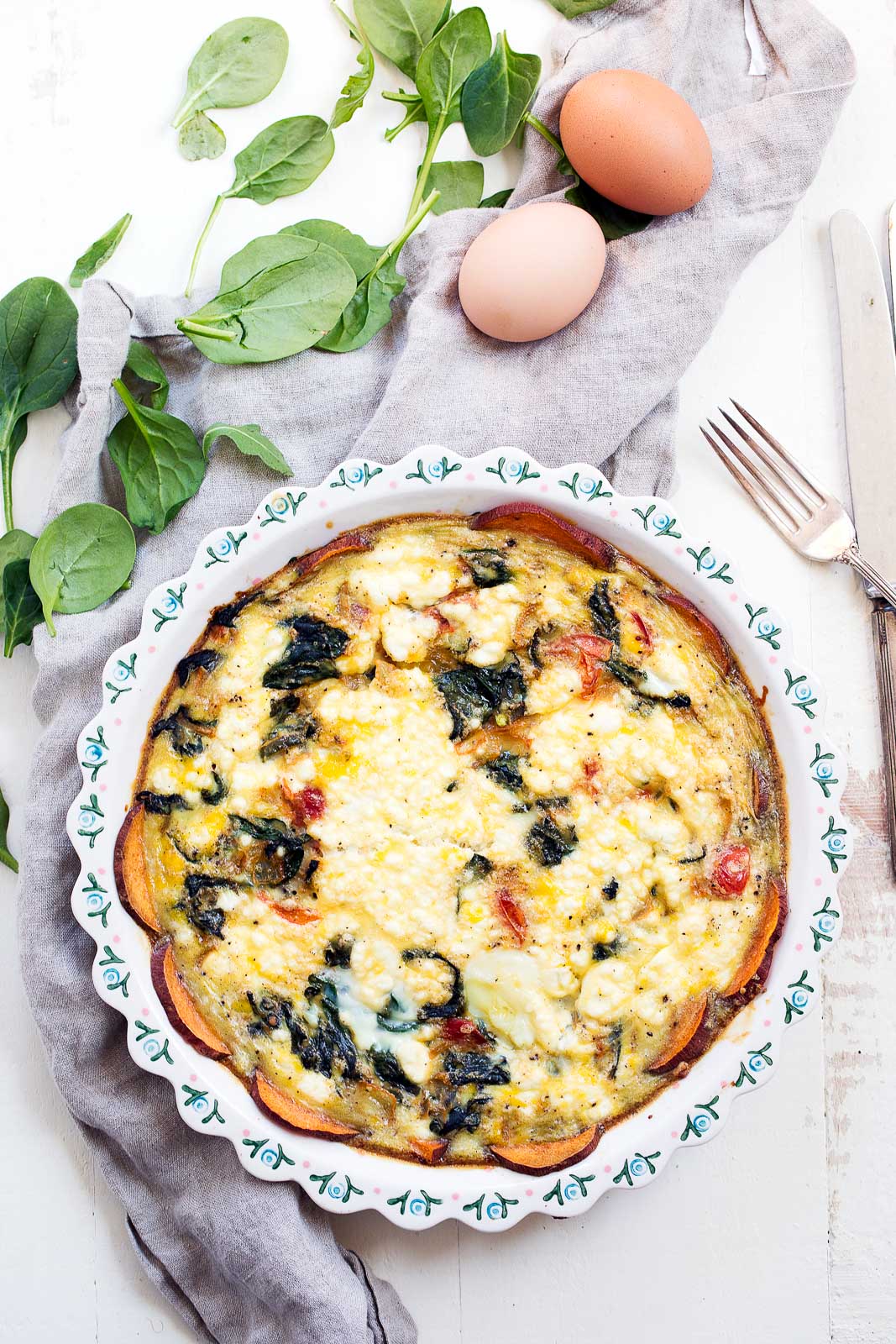 easy spinach and goat cheese quiche with sweet potato crust in a pie pan