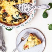 spinach and goat cheese quiche on a plate with a fork