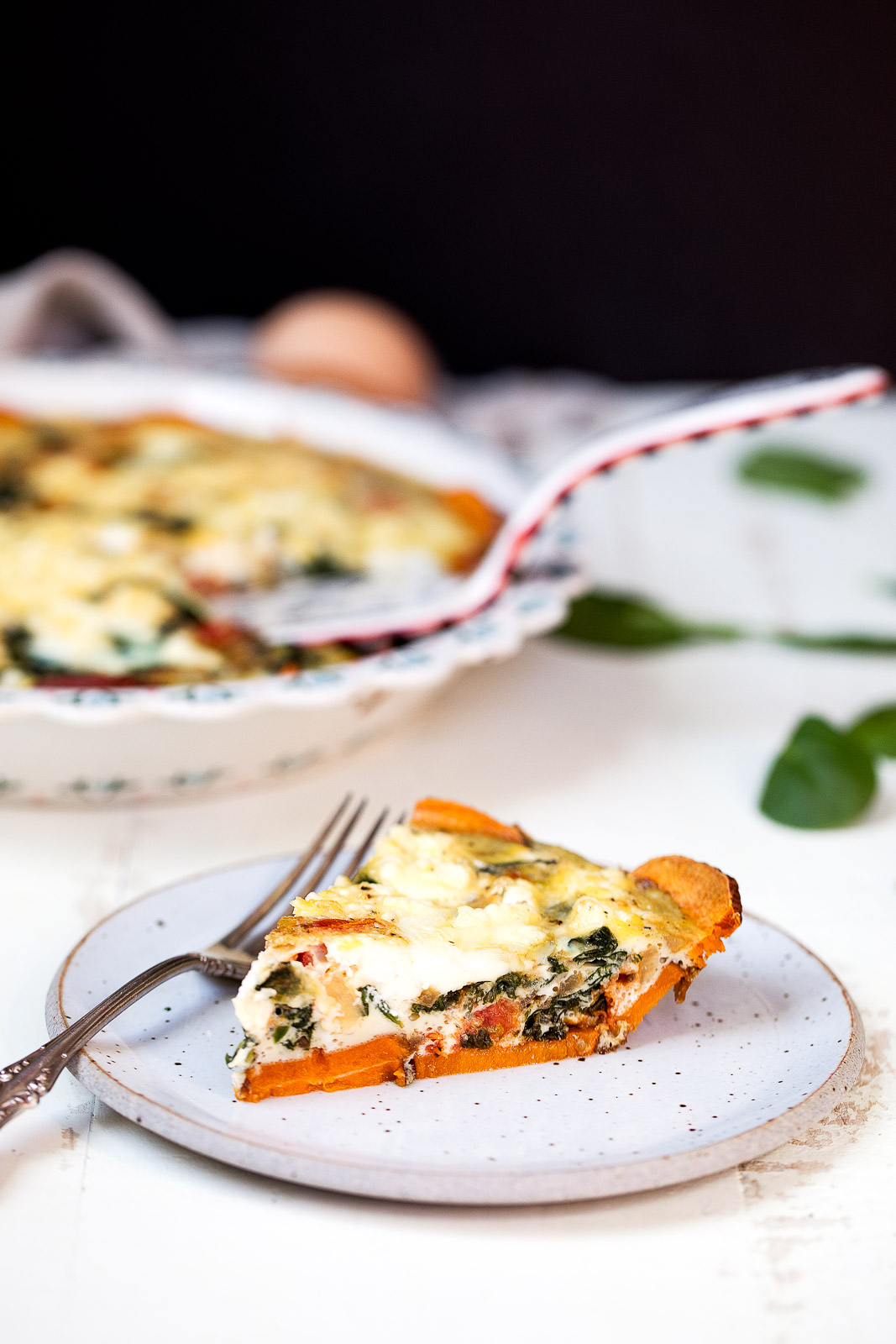 Spinach and goat cheese quiche with sweet potato crust on a plate