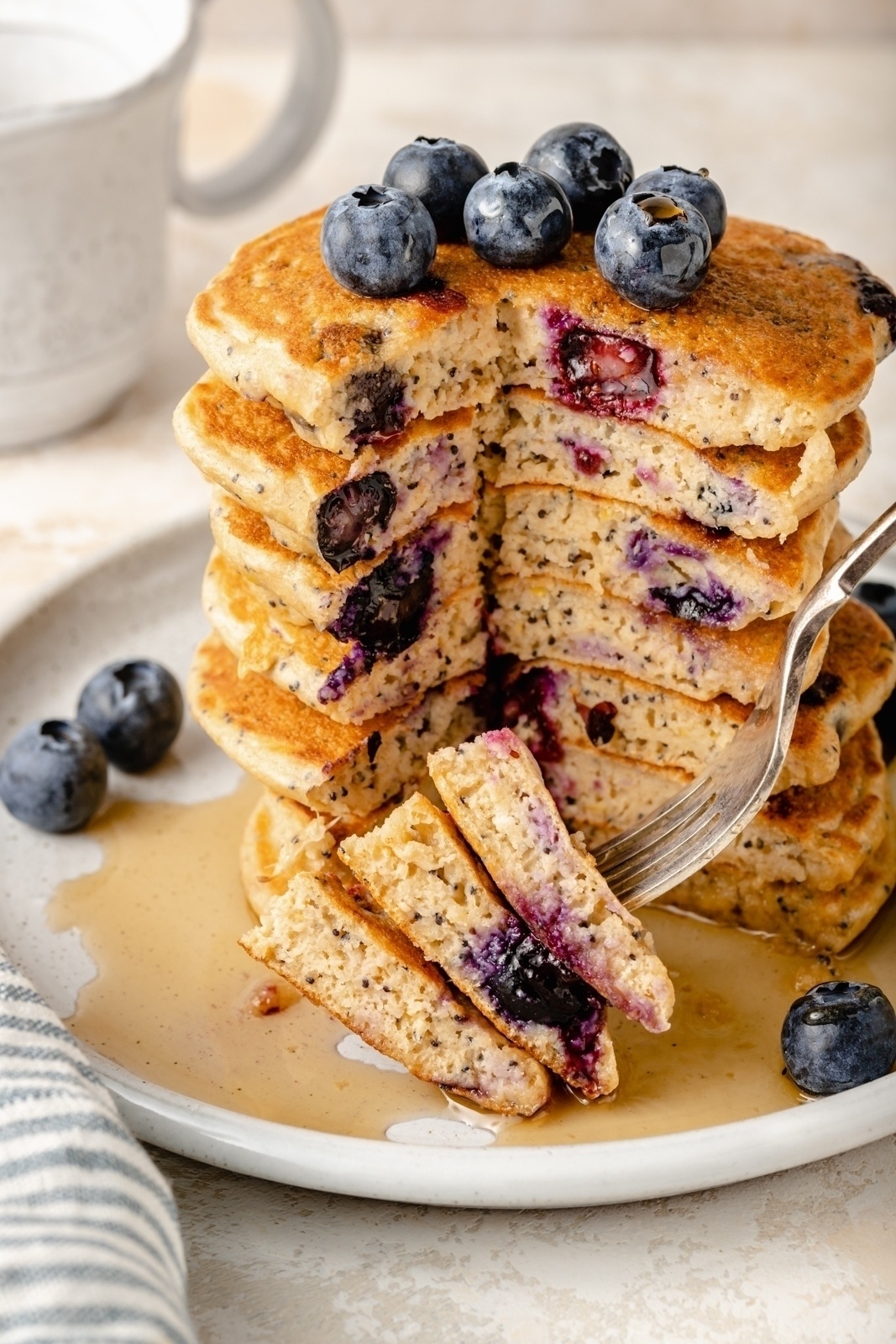 sliced stack of lemon blueberry yogurt pancakes on a plate with a fork