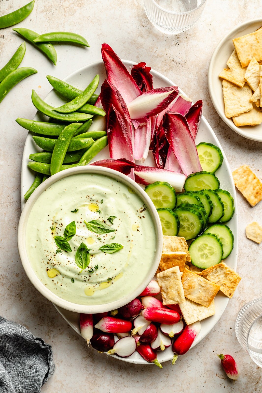 healthy cottage cheese dip in a bowl next to vegetables and pita chips