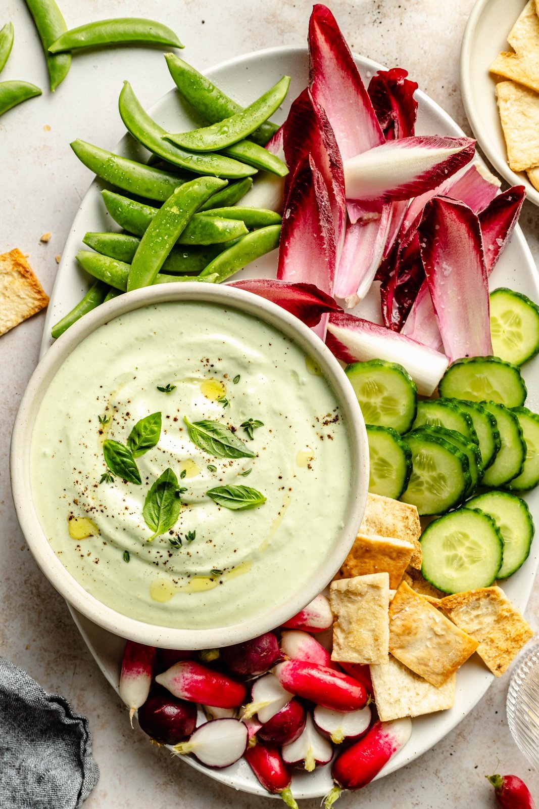 garlic herb cottage cheese dip in a bowl next to vegetables and crackers