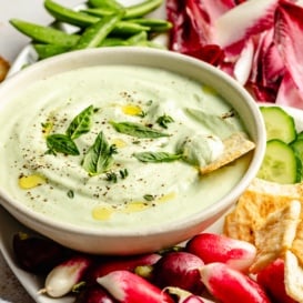 herb cottage cheese dip in a bowl next to vegetables