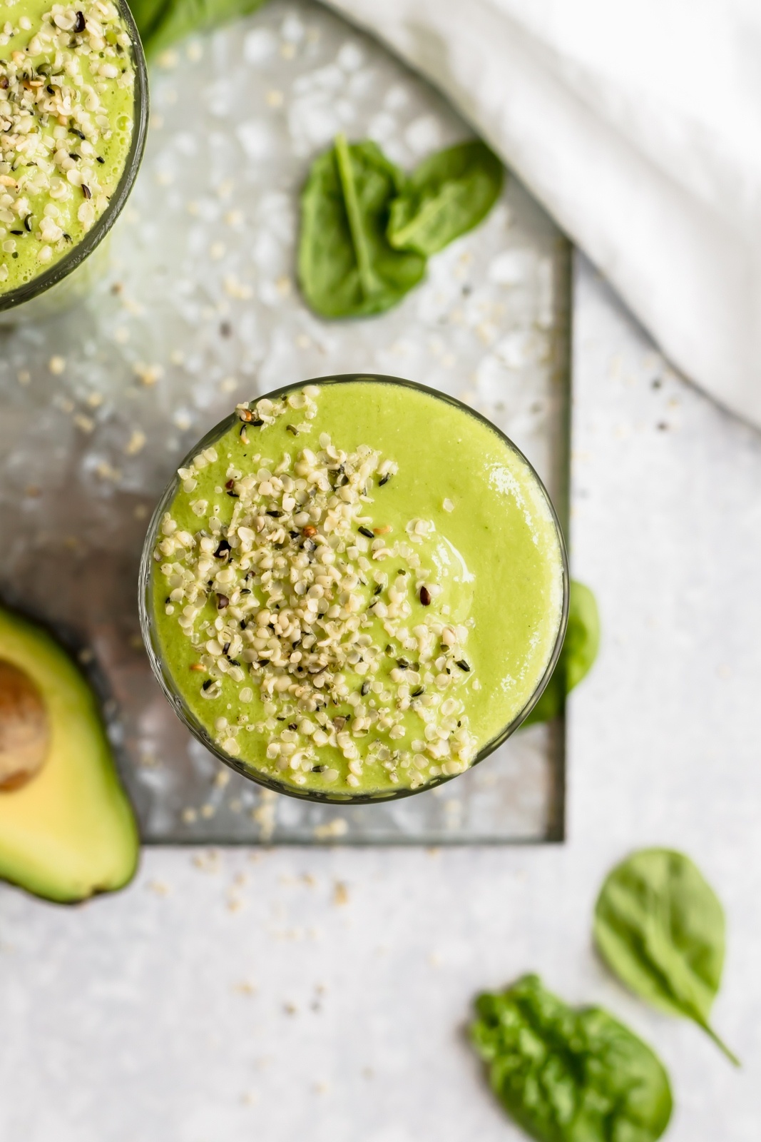 avocado green smoothie in a glass with hemp seeds on top