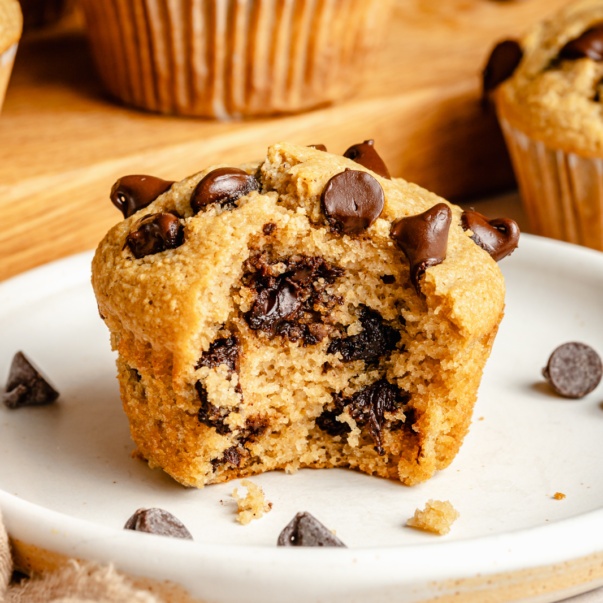 gluten free chocolate chip muffin on a plate with a bite taken out