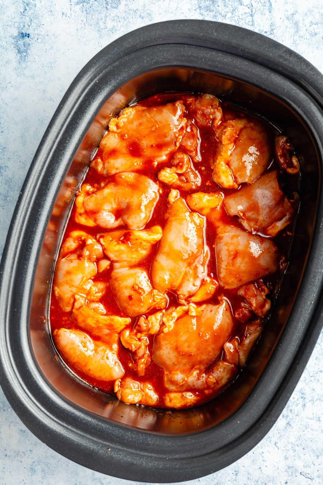 uncooked gochujang pulled chicken in a slow cooker to make sandwiches