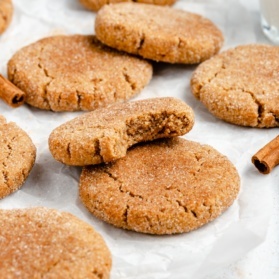 gluten free snickerdoodles on parchment paper with a bite taken out