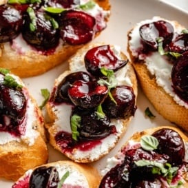 grilled crostini with roasted cherries and ricotta on a platter