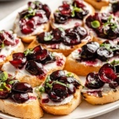 grilled crostini with roasted cherries and ricotta on a platter