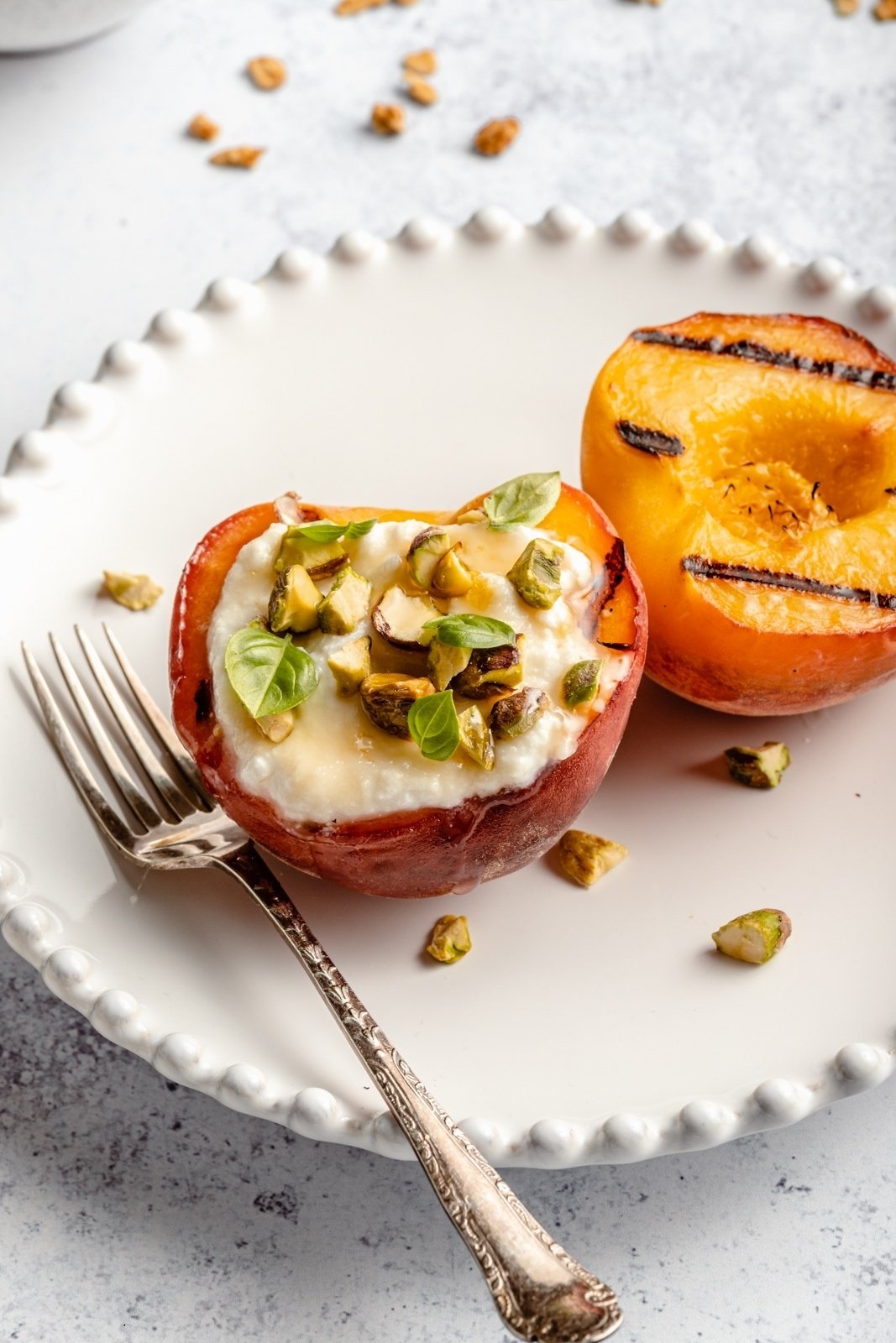 grilled peaches on a plate with a ricotta topping