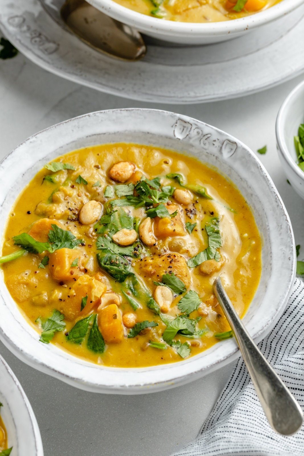 blended butternut squash lentil soup in a bowl topped with cilantro