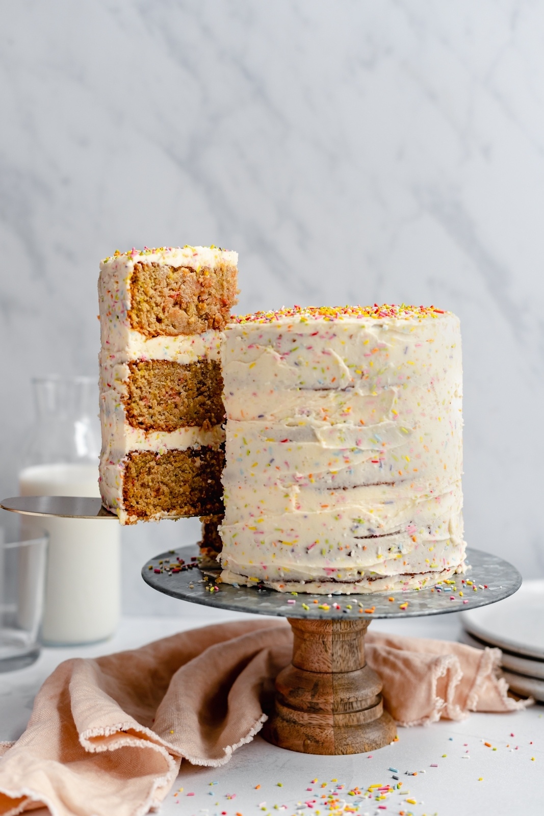 pulling a slice of healthy birthday cake out from a cake stand