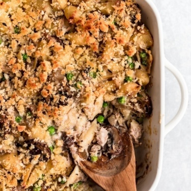 healthy tuna noodle casserole in a pan with a wooden spoon