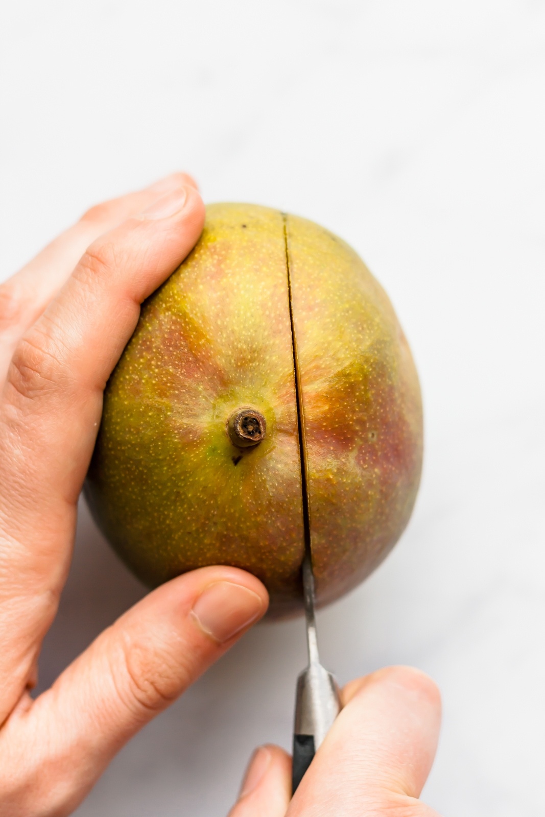 cutting a mango with a knife