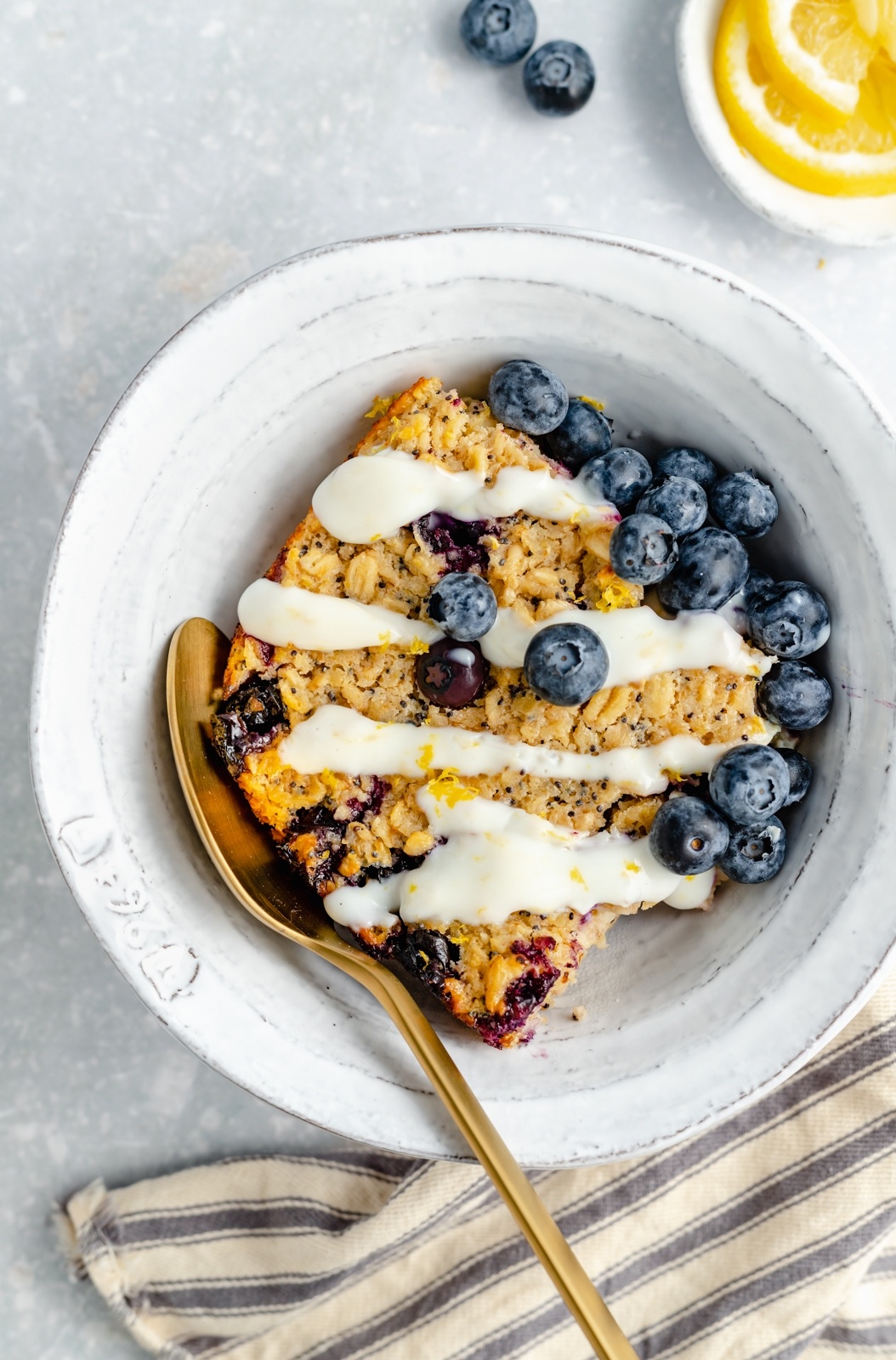 slice of lemon blueberry baked oatmeal with blueberries in a bowl