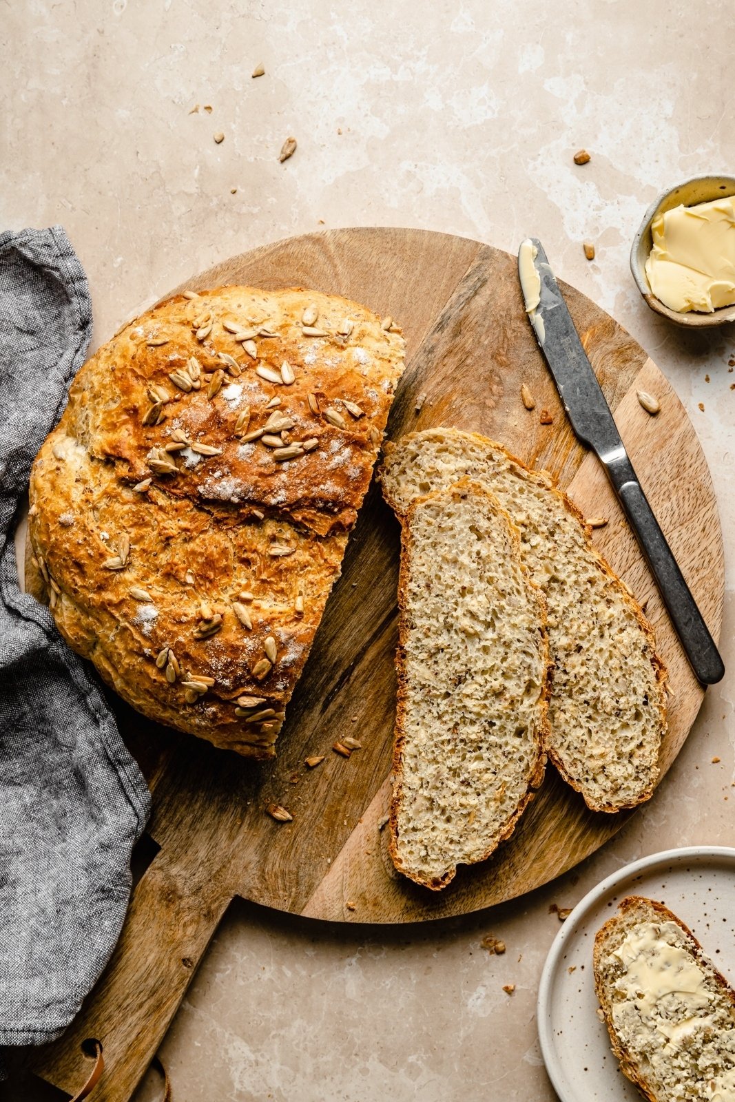 easy honey oatmeal artisan bread sliced on a wooden cutting board