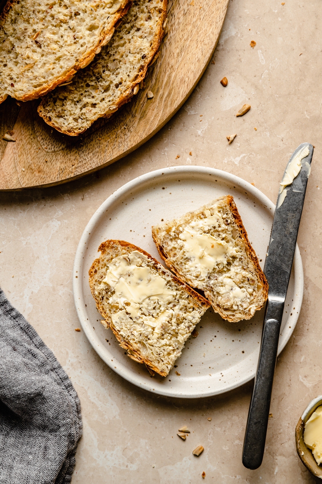 slice of homemade artisan bread with butter on a plate