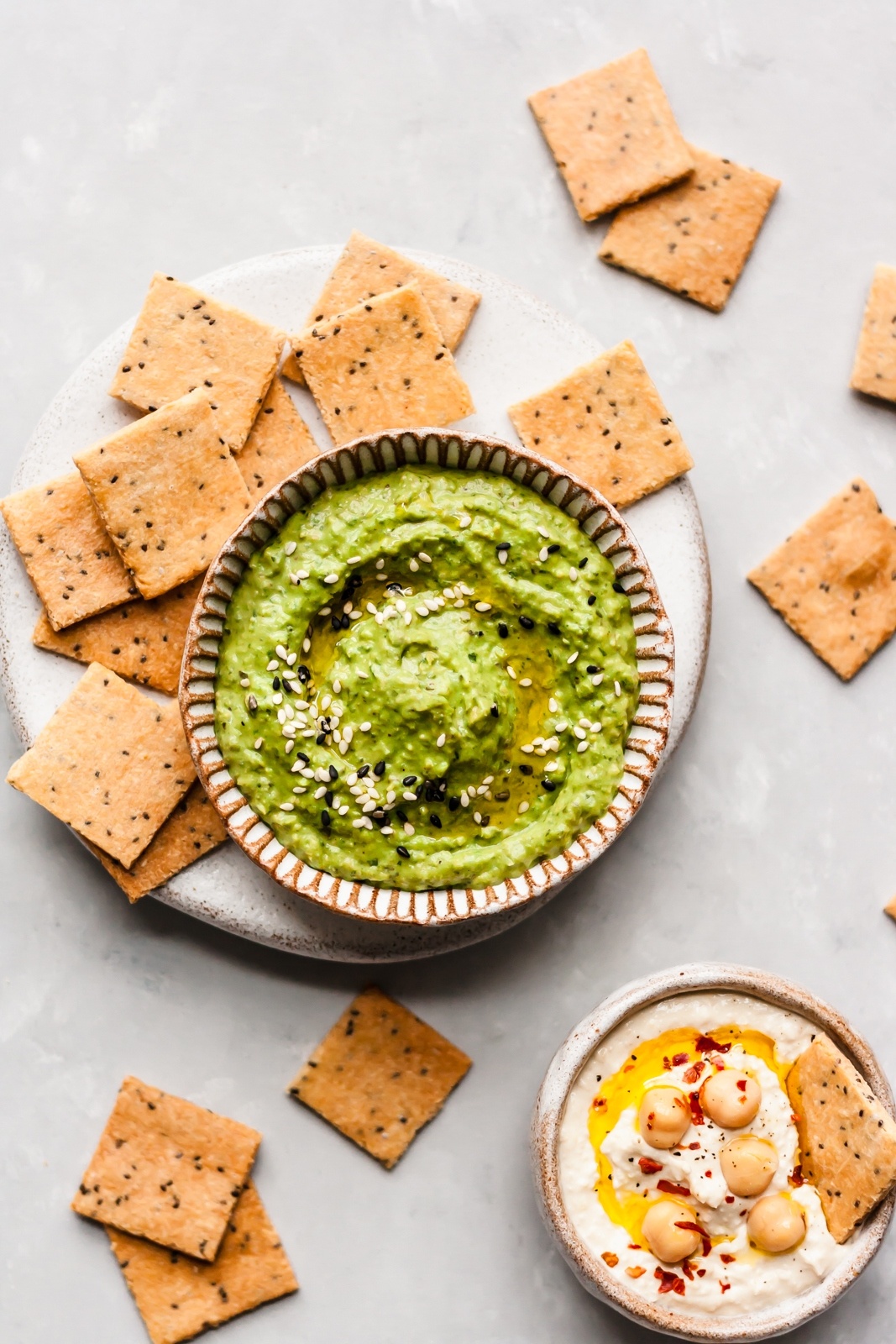 paleo crackers next to two bowls of hummus