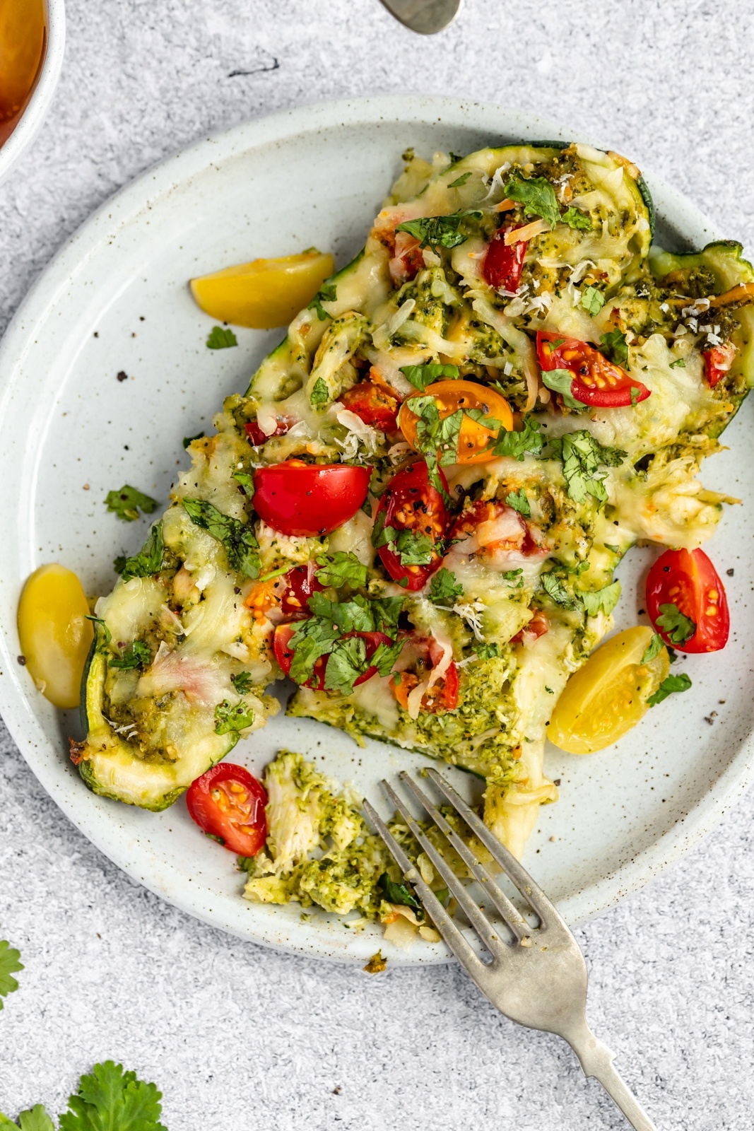 easy pesto chicken stuffed zucchini boats on a plate