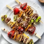 fruit skewers with chocolate on a plate