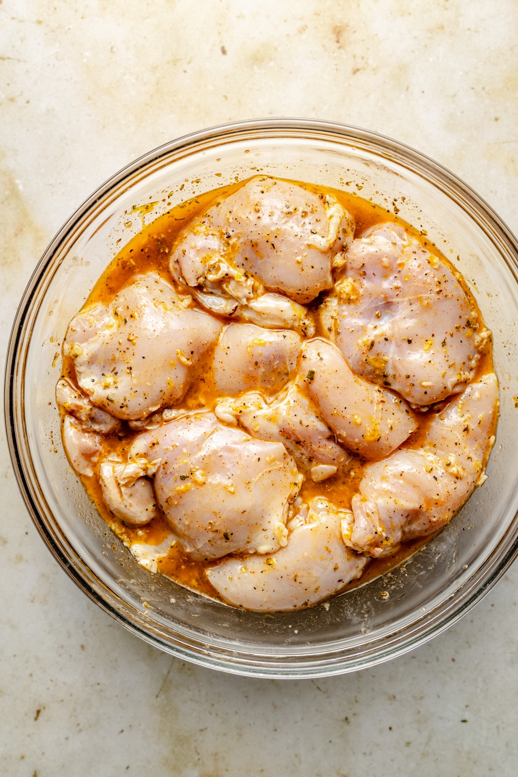 marinating chicken in a bowl to make lemon garlic chicken