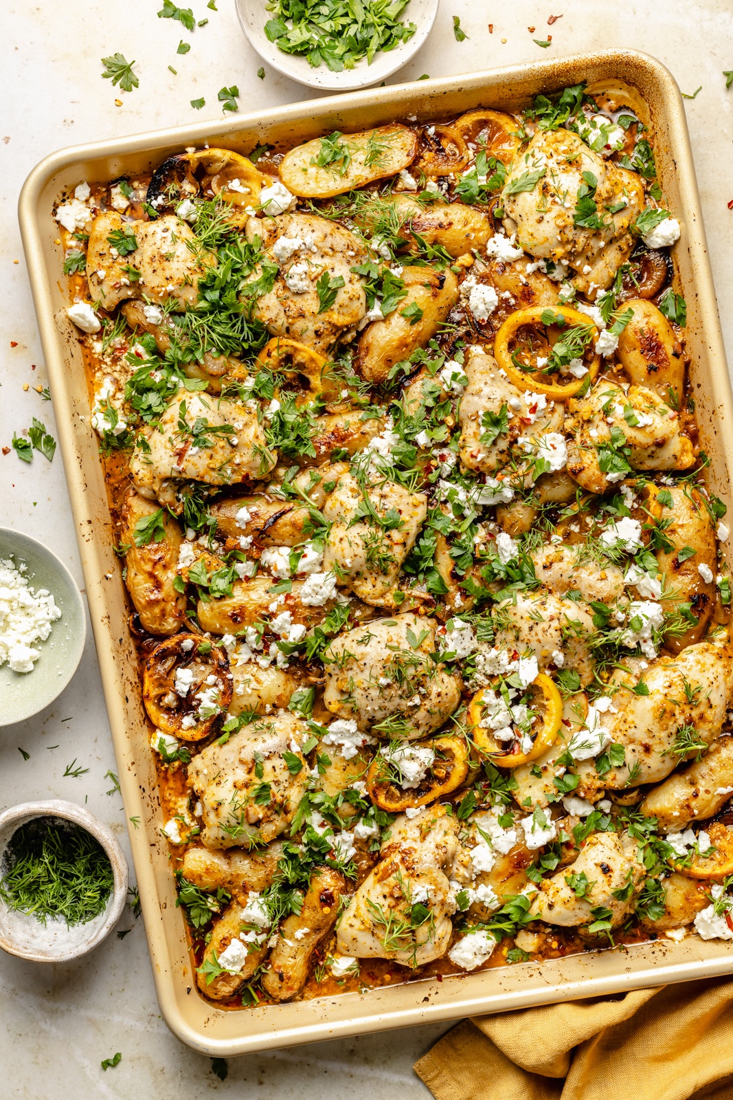 sheet pan lemon chicken and potatoes topped with feta and herbs