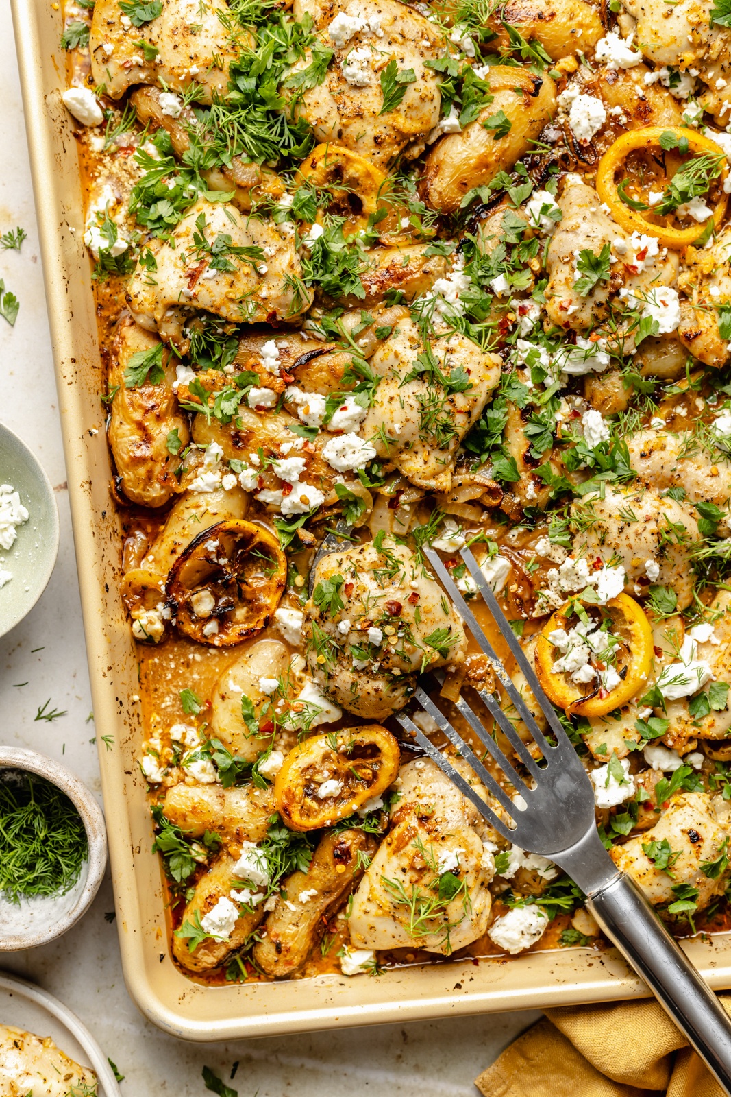 sheet pan lemon chicken and potatoes topped with herbs