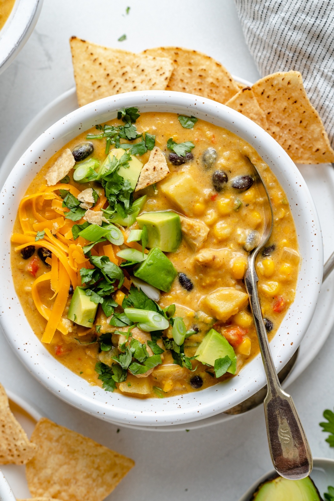 bowl of southwest chicken corn chowder topped with cilantro and avocado