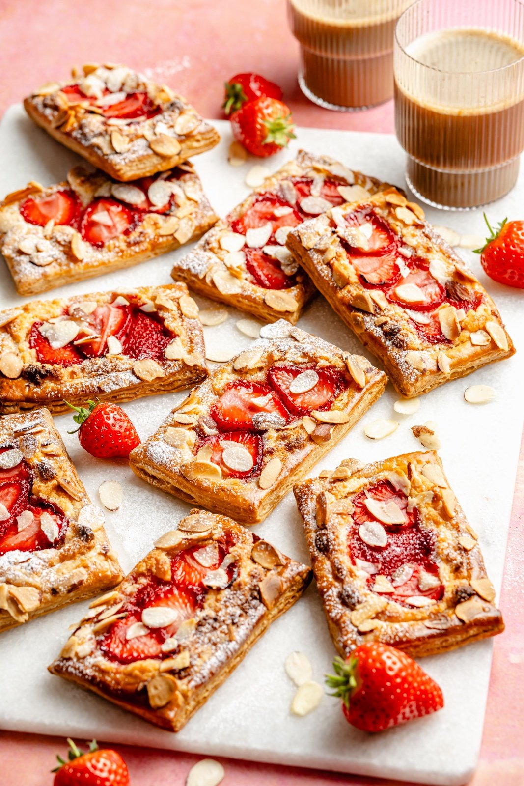 strawberry puff pastry tarts with almonds on a white board