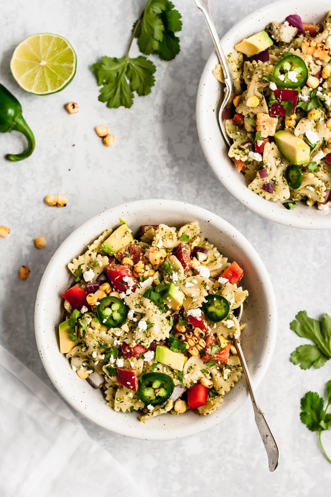 healthy street corn pasta salad in two bowls with two forks