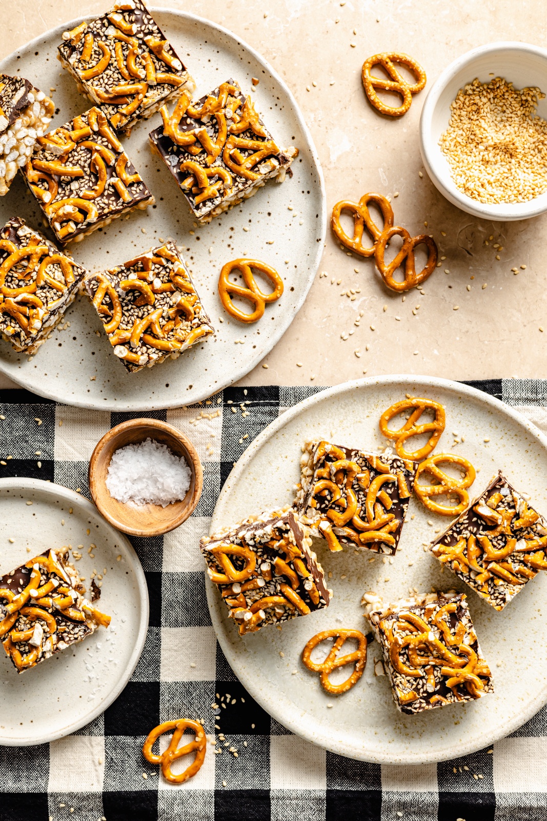 no bake chocolate tahini rice krispie treats topped with pretzels on plates