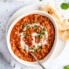 vegan tomato lentil soup in a bowl with naan