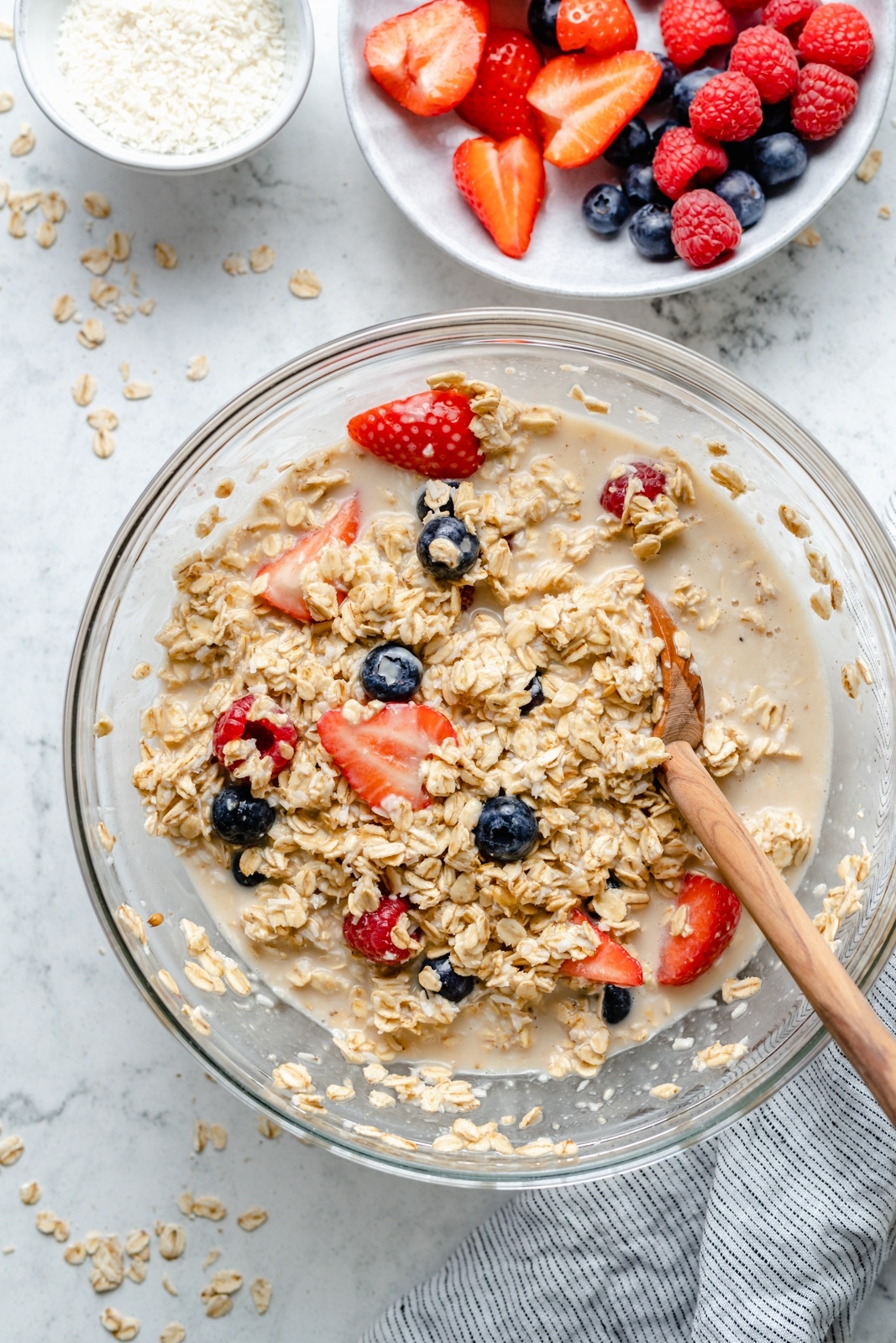 mixing berries and cream baked oatmeal batter in a bowl